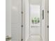 Hallway showcases an open doorway to a light-filled room with large windows and hardwood floors, creating an inviting space at 1819 Bella Casa Ct, Tampa, FL 33618