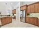 Well-appointed kitchen showcasing wood cabinets, granite countertops, stainless steel refrigerator, and a built-in desk at 1819 Bella Casa Ct, Tampa, FL 33618