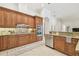 Modern kitchen with stainless steel appliances, wood cabinets, granite countertops, and a tiled backsplash at 1819 Bella Casa Ct, Tampa, FL 33618
