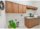 Bright laundry room featuring wooden cabinets, sink, granite countertops and extra hanging rod at 1819 Bella Casa Ct, Tampa, FL 33618