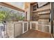 Outdoor kitchen featuring stone accents, stainless steel appliances, grill and counter seating at 1819 Bella Casa Ct, Tampa, FL 33618