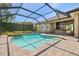 Inviting screened-in pool area with a spa, outdoor kitchen and lush landscaping at 1819 Bella Casa Ct, Tampa, FL 33618