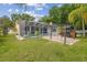 Expansive backyard featuring a screened-in pool, patio with grill, and lush lawn at 23211 Lucerne Pl, Land O Lakes, FL 34639