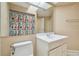 Bathroom featuring a single sink vanity, toilet, tile flooring and colorful shower curtain at 23211 Lucerne Pl, Land O Lakes, FL 34639