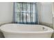 Close up of a soaking tub in a bathroom with tiled walls and a large window at 23211 Lucerne Pl, Land O Lakes, FL 34639