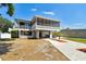 Elevated waterfront home featuring a large balcony and charming landscaping at 23211 Lucerne Pl, Land O Lakes, FL 34639