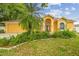 Charming yellow home with a well-manicured lawn, lush landscaping and double door entry at 23211 Lucerne Pl, Land O Lakes, FL 34639