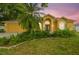 Charming yellow home with a well-manicured lawn, lush landscaping and double door entry at 23211 Lucerne Pl, Land O Lakes, FL 34639