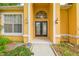 Close up of the beautiful yellow house featuring a decorative front door and address number at 23211 Lucerne Pl, Land O Lakes, FL 34639