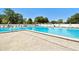 Community pool with sun loungers and a bright blue sky at 23211 Lucerne Pl, Land O Lakes, FL 34639