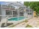 Relaxing pool area surrounded by a screened enclosure and manicured landscaping at 23211 Lucerne Pl, Land O Lakes, FL 34639