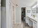 Bright bathroom featuring a vanity with a marble countertop and a view of a closet at 2400 Winding Creek Blvd # 2-201, Clearwater, FL 33761