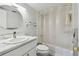 Bright bathroom featuring a round mirror and shower/tub combination at 2400 Winding Creek Blvd # 2-201, Clearwater, FL 33761