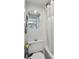 Bright bathroom featuring a bathtub and a round mirror above the toilet at 2400 Winding Creek Blvd # 2-201, Clearwater, FL 33761