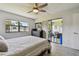 Comfortable bedroom featuring a large bed, ceiling fan, and a sliding glass door at 2400 Winding Creek Blvd # 2-201, Clearwater, FL 33761
