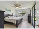 Comfortable bedroom featuring a large bed, ceiling fan, and a sliding glass door at 2400 Winding Creek Blvd # 2-201, Clearwater, FL 33761