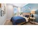 Stylishly decorated bedroom featuring a blue accent wall, neutral carpet, and bright natural light at 29477 Velletri Ln, Wesley Chapel, FL 33543