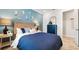 Comfortable bedroom featuring a blue accent wall, neutral carpet, and a decorative chest of drawers at 29477 Velletri Ln, Wesley Chapel, FL 33543