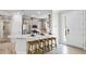 Bright kitchen with modern appliances, stylish cabinets, quartz countertops and an island with bar stool seating by the entry door at 29477 Velletri Ln, Wesley Chapel, FL 33543