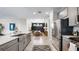 Modern kitchen with gray cabinets, stainless steel appliances, and a view into the dining room at 29477 Velletri Ln, Wesley Chapel, FL 33543