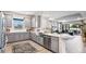 Open kitchen featuring gray cabinets, stainless steel appliances, and views into the adjacent living and dining areas at 29477 Velletri Ln, Wesley Chapel, FL 33543