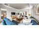 Open-concept living room featuring a comfortable blue sofa and stylish decor with seamless access to the bedroom and kitchen area at 29477 Velletri Ln, Wesley Chapel, FL 33543