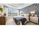 Serene main bedroom with a large window, tray ceiling, and elegant wallpaper, creating a relaxing retreat at 29477 Velletri Ln, Wesley Chapel, FL 33543