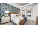 Serene main bedroom with a large window, tray ceiling, and elegant wallpaper, creating a relaxing retreat at 29477 Velletri Ln, Wesley Chapel, FL 33543