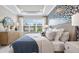 Serene main bedroom with a large window, tray ceiling, and elegant wallpaper, creating a relaxing retreat at 29477 Velletri Ln, Wesley Chapel, FL 33543