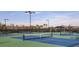 Multiple community tennis courts with blue and green surface and lighting for evening play at 29477 Velletri Ln, Wesley Chapel, FL 33543