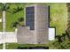 Aerial view showing a home with solar panels on the roof, surrounded by a well-maintained yard and mature trees at 2955 Briar Cliff Dr, Palm Harbor, FL 34684