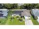 Aerial view of home with solar panels, well-maintained lawn, and mature landscaping at 2955 Briar Cliff Dr, Palm Harbor, FL 34684