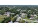 An aerial view capturing a community with homes and a large institutional building surrounded by trees and green spaces at 2955 Briar Cliff Dr, Palm Harbor, FL 34684