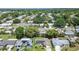 An aerial view of a residential neighborhood with mature trees and well-maintained homes, some featuring solar panels at 2955 Briar Cliff Dr, Palm Harbor, FL 34684