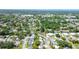 An aerial perspective of a well-planned residential community featuring tidy homes, green spaces, a pond, and orderly street layouts at 2955 Briar Cliff Dr, Palm Harbor, FL 34684