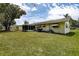 Beautiful backyard features a well-maintained lawn, screened-in porch, and mature trees at 2955 Briar Cliff Dr, Palm Harbor, FL 34684