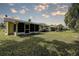 Well-maintained backyard with lush green lawn and screened in porch provides an outdoor living space at 2955 Briar Cliff Dr, Palm Harbor, FL 34684