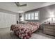 Bright bedroom features a ceiling fan, white shuttered windows, and ample closet space at 2955 Briar Cliff Dr, Palm Harbor, FL 34684