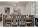 Inviting dining room with rustic table, modern lighting fixture, and plantation shutters at 2955 Briar Cliff Dr, Palm Harbor, FL 34684