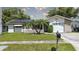 Charming single-story home with well-maintained lawn, palm trees, and solar panels, offering curb appeal and energy efficiency at 2955 Briar Cliff Dr, Palm Harbor, FL 34684
