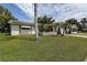 A charming home with solar panels, palm trees, and a well-kept lawn, creating a welcoming and eco-friendly appeal at 2955 Briar Cliff Dr, Palm Harbor, FL 34684