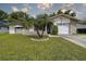 Inviting home exterior with lush lawn, palm tree landscaping, and a clean, well-maintained facade, complete with solar panels at 2955 Briar Cliff Dr, Palm Harbor, FL 34684
