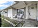 Cozy front porch featuring outdoor seating and a view of the manicured lawn, complemented by the home's inviting exterior at 2955 Briar Cliff Dr, Palm Harbor, FL 34684