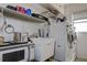 Well-organized laundry room with front-load washer and dryer, utility sink, microwave, and ample storage shelves at 2955 Briar Cliff Dr, Palm Harbor, FL 34684