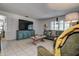 Bright living area with tile floors, comfortable seating, and a large screen TV, perfect for relaxation and entertainment at 2955 Briar Cliff Dr, Palm Harbor, FL 34684