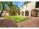 Spacious backyard featuring well-maintained artificial grass, tropical landscaping, and a covered patio at 326 16Th Ne Ave, St Petersburg, FL 33704