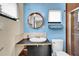 Stylish bathroom with a bright blue wall, a round mirror, and a walk-in shower at 326 16Th Ne Ave, St Petersburg, FL 33704