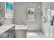 Modern bathroom featuring gray tile, a bathtub, walk-in shower, and natural light at 326 16Th Ne Ave, St Petersburg, FL 33704