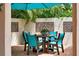 Outdoor dining area with brown table, turquoise chairs, string lights, umbrella, and privacy wall at 326 16Th Ne Ave, St Petersburg, FL 33704
