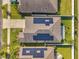 Overhead view of homes with solar panels on the roofs, surrounded by green lawns and white fences, capturing sustainable living at 4201 Globe Thistle Dr, Tampa, FL 33619
